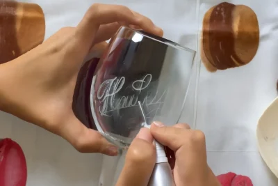 Close-up of laser glass engraving process creating custom designs.